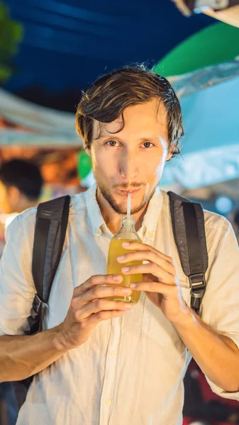 Man drinking sugar cane juice on the Asian market VERTICAL FORMAT for Instagram mobile story or stories size. Mobile wallpaper — Stock Photo, Image