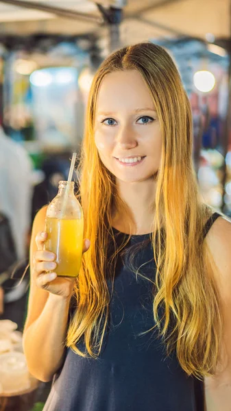 Женщина пьет сок сахарного тростника на азиатском рынке VERTICAL FORMAT для мобильных Instagram история или размер историй. Мобильные обои — стоковое фото