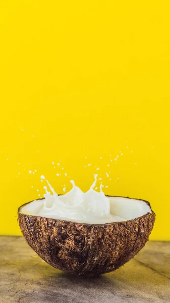 Fruta de coco e leite respingo dentro dele em fundo amarelo FORMATO VERTICAL para Instagram história móvel ou tamanho de histórias. Papel de parede móvel — Fotografia de Stock