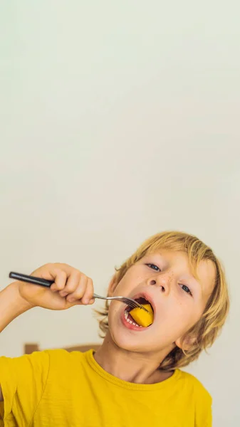 Pojken äter frukt. Hälsosam mat för barn. Barnet äta hälsosamt mellanmål. Vegetarisk kost för barn. Vitaminer för barn vertikalt Format för Instagram mobila berättelse eller berättelser storlek. Mobila tapeter — Stockfoto