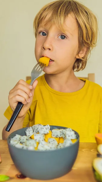 Мальчик ест фрукты. Здоровое питание для детей. Ребенок ест здоровые закуски. Вегетарианское питание для детей. Витамины для детей ВЕРТИЧЕСКИЙ ФОРМАТ для мобильной истории Instagram или размера историй. Мобильные обои — стоковое фото