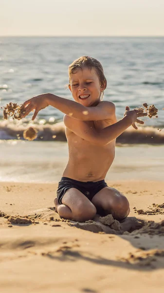 Il ragazzo urla e impazzisce sulla spiaggia, getta sabbia. Tantrum concept VERTICAL FORMAT per Instagram storia mobile o dimensioni storie. Carta da parati mobile — Foto Stock