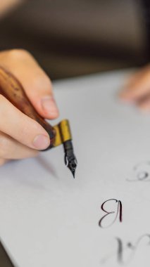 Hattat eller yazar ifade beyaz kağıt üzerinde. Süs süslü harfler inscribing. Hat sanatı hocası, grafik tasarım, harfler, el yazısı, yaratma kavramı Instagram mobil için dikey biçim