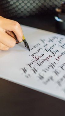 Hattat eller yazar ifade beyaz kağıt üzerinde. Aşk Inscribing süs süslü harfler hakkında İncil ifade. Hat sanatı hocası, grafik tasarım, harfler, el yazısı, yaratma kavramı dikey biçimi