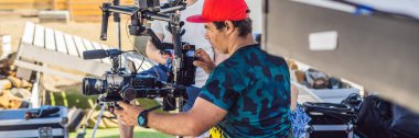 Steadicam Operatörü ve asistanı kamera ve 3 eksenli sabitleyici-gimbal bir ticari çekmek için afiş, uzun biçimde hazırlamak