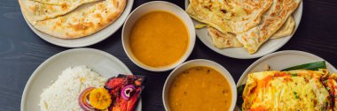 Koyu ahşap arka plan üzerinde çeşitli Hint yemeği. Yemekler ve mezeler Hint Mutfak. Köri, tereyağı tavuk, pirinç, mercimek, paneer, samosa, naan, Hint turşusu, baharatlar. Kase ve Hint yemekleri ile plakalar