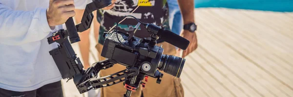 L'operatore steadicam professionale utilizza un sistema di stabilizzazione della fotocamera a 3 assi su un set di produzione commerciale BANNER, FORMATO LUNGO — Foto Stock