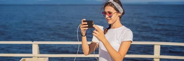 Cruise ship woman using mobile phone on travel vacation at ocean. Girl texting sms on wifi on tropical holidays. Internet on international seas concept. Tourist looking at her holiday pictures BANNER — Stock Photo, Image