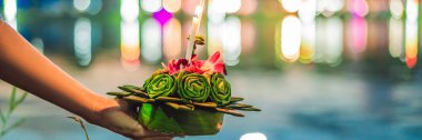 Genç kadın Loy Krathong, su üzerinde çalışan kutluyor. İnsanlar çiçek ve mum yakıp uzun Tayland afiş, Loy Krathong Festivali kutlamak için su üzerinde yüzer Loy Krathong Festivali, satın