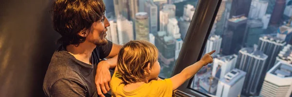 Папа и сын смотрят на городской пейзаж Куала-Лумпур. Вид на город Куала-Лумпур вечером на закате небоскребов в Малайзии. Путешествие с детьми концепция баннер, длинный формат — стоковое фото