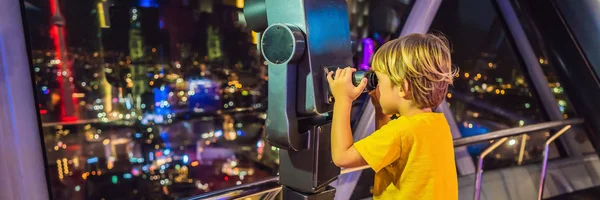 小男孩看着瓜拉伦普尔的城市景观。在马来西亚的日落摩天大楼大楼里, 可以欣赏到吉隆坡城市天际线的全景。旅行与孩子的概念横幅, 长格式 — 图库照片