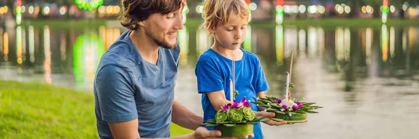 Father and son tourists celebrates Loy Krathong, Runs on the water. Loy Krathong festival, People buy flowers and candle to light and float on water to celebrate the Loy Krathong festival in Thailand