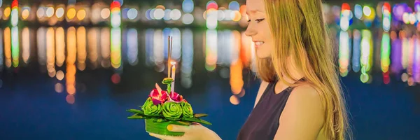 Young woman celebrates Loy Krathong, Runs on the water. Loy Krathong festival, People buy flowers and candle to light and float on water to celebrate the Loy Krathong festival in Thailand BANNER, LONG