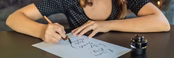 Kalligráfus fiatal nő fehér papírra írja a kifejezést. Álom big, készlet cél, műveletet. Díszes, díszített betűk inscribing. Kalligráfia, grafikai tervezés, betűk, kézírás, létrehozása — Stock Fotó