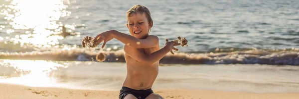 A fiú sikolyok és a furcsaság ki a strandon, dob homok. Hisztit koncepció Banner, hosszú formátumban — Stock Fotó