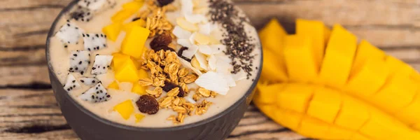 Smoothie-Schalen mit Mango, Banane, Müsli, Kokosraspeln, Drachenfrüchten, Chiasamen und Minze auf Holzgrund. Konzept Früchte, Vitamine Banner, Langformat — Stockfoto