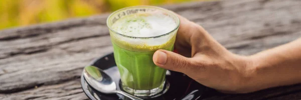 Γυναικείο χέρι εκμετάλλευση φλιτζάνι matcha Latte, πράσινο τσάι, σε παλιό τραπέζι ξύλινο φόντο πανό, μεγάλη μορφή — Φωτογραφία Αρχείου