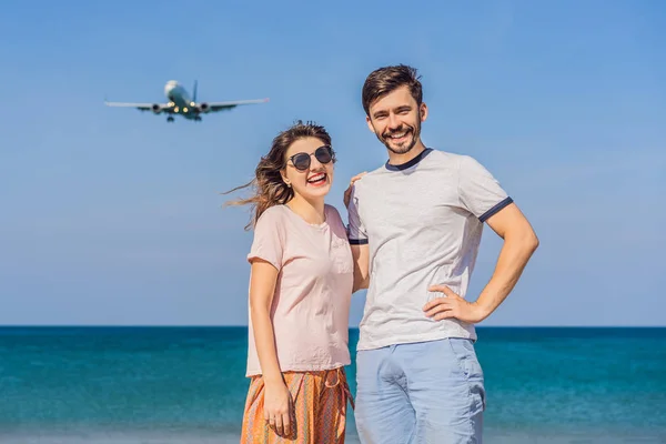 Homem e mulher turistas se divertir na praia assistindo os aviões de desembarque. Viajando em um conceito de avião. Espaço de texto. Ilha Phuket na Tailândia. Paraíso impressionante. Praia quente Mai Khao. Incrível. — Fotografia de Stock