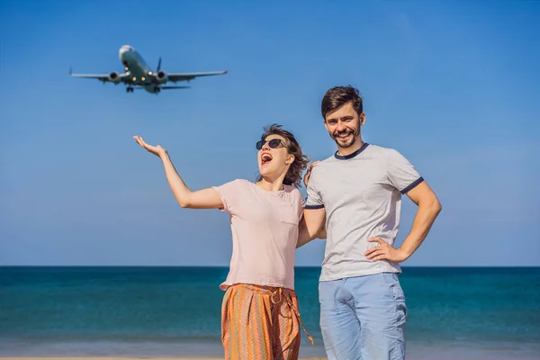 Hombre y mujer turistas se divierten en la playa viendo los aviones de aterrizaje. Viajando en un concepto de avión. Espacio de texto. Island Phuket en Tailandia. Impresionante paraíso. Playa caliente Mai Khao. Increíble. — Foto de Stock