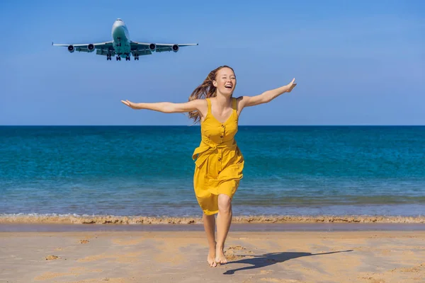 Woman have fun on the beach watching the landing planes. Traveling on an airplane concept. Text space. Island Phuket in Thailand. Impressive paradise. Hot beach Mai Khao. Amazing landscape VERTICAL