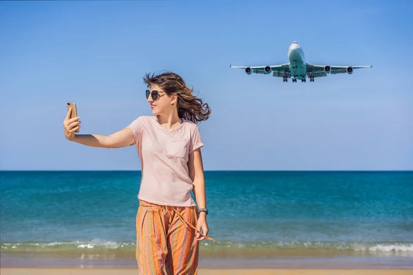 La mujer hace una selfie en la playa viendo los aviones de aterrizaje. Viajando en un concepto de avión. Espacio de texto. Island Phuket en Tailandia. Impresionante paraíso. Playa caliente Mai Khao. Paisaje increíble —  Fotos de Stock