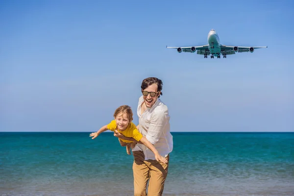 Papà e figlio si divertono sulla spiaggia a guardare gli aerei di atterraggio. Viaggiare su un aereo con il concetto di bambini. Spazio di testo. Island Phuket in Thailandia. Un paradiso impressionante. Spiaggia calda Mai Khao. Incredibile. — Foto Stock