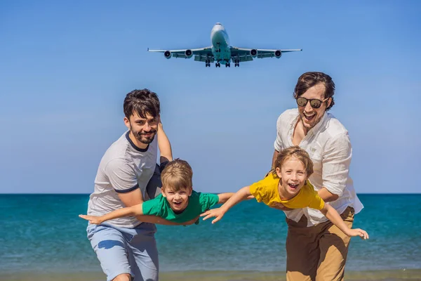 Dois pais e dois filhos se divertem na praia assistindo os aviões de pouso. Viajar em um avião com conceito de crianças. Espaço de texto. Ilha Phuket na Tailândia. Paraíso impressionante. Praia quente Mai Khao — Fotografia de Stock