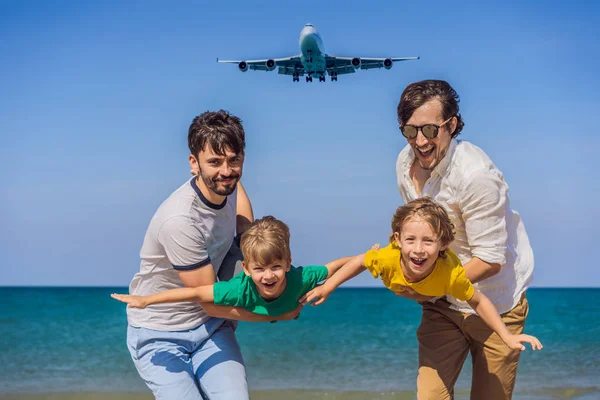 Due papà e due figli si divertono sulla spiaggia a guardare gli aerei di atterraggio. Viaggiare su un aereo con il concetto di bambini. Spazio di testo. Island Phuket in Thailandia. Un paradiso impressionante. Spiaggia calda Mai Khao — Foto Stock