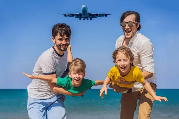 Due papà e due figli si divertono sulla spiaggia a guardare gli aerei di atterraggio. Viaggiare su un aereo con il concetto di bambini. Spazio di testo. Island Phuket in Thailandia. Un paradiso impressionante. Spiaggia calda Mai Khao — Foto Stock