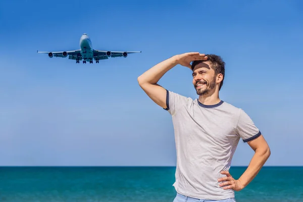 Uomo turista divertirsi sulla spiaggia a guardare gli aerei di atterraggio. Viaggiare su un concetto di aereo. Spazio di testo. Island Phuket in Thailandia. Un paradiso impressionante. Spiaggia calda Mai Khao. Paesaggio incredibile — Foto Stock