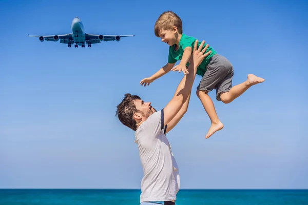 Papà e figlio si divertono sulla spiaggia a guardare gli aerei di atterraggio. Viaggiare su un aereo con il concetto di bambini. Spazio di testo. Island Phuket in Thailandia. Un paradiso impressionante. Spiaggia calda Mai Khao. Incredibile. — Foto Stock