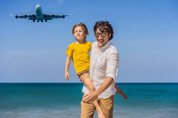 Papà e figlio si divertono sulla spiaggia a guardare gli aerei di atterraggio. Viaggiare su un aereo con il concetto di bambini. Spazio di testo. Island Phuket in Thailandia. Un paradiso impressionante. Spiaggia calda Mai Khao. Incredibile. — Foto Stock