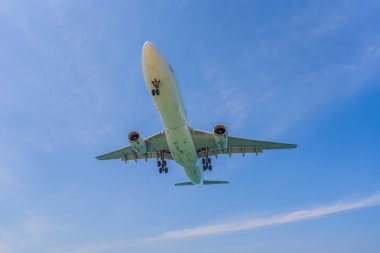 Açık mavi gökyüzünde uçan beyaz bir uçak