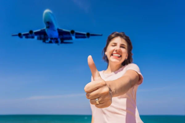 Donna mostra un anello con un aeroplano divertirsi sulla spiaggia a guardare gli aerei di atterraggio. Viaggiare su un concetto di aereo. Spazio di testo. Island Phuket in Thailandia. Un paradiso impressionante. Spiaggia calda Mai Khao — Foto Stock