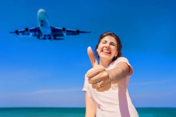 Donna mostra un anello con un aeroplano divertirsi sulla spiaggia a guardare gli aerei di atterraggio. Viaggiare su un concetto di aereo. Spazio di testo. Island Phuket in Thailandia. Un paradiso impressionante. Spiaggia calda Mai Khao — Foto Stock