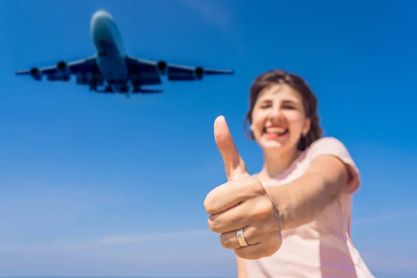Η γυναίκα δείχνει ένα δαχτυλίδι με ένα αεροπλάνο να διασκεδάζει στην παραλία βλέποντας τα αεροπλάνα προσγείωσης. Ταξιδεύοντας με την έννοια του αεροπλάνου. Χώρος κειμένου. Νησί Πουκέτ στην Ταϊλάνδη. Εντυπωσιακός παράδεισος. Παραλία Μάι Κάο — Φωτογραφία Αρχείου