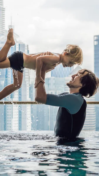 Mavi gökyüzü şehir manzaralı açık yüzme havuzunda baba ve oğul Instagram Mobil hikaye veya hikayeler boyutu için dikey Format. Mobil duvar kağıdı