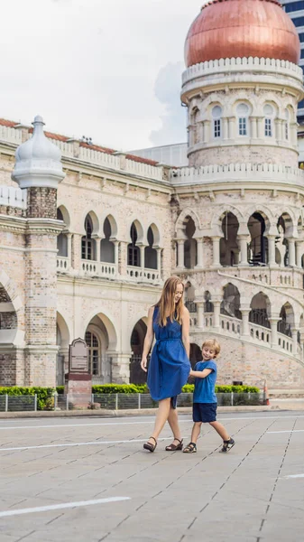 Mom and son on background of Sultan Abdul Samad Building in Kuala Lumpur, Malaysia. Traveling with children concept VERTICAL FORMAT for Instagram mobile story or stories size. Mobile wallpaper — Stock Photo, Image