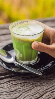 Kadın el holding matcha Latte, yeşil çay, eski ahşap arka plandaki tabloda dikey biçim Instagram mobil hikaye veya hikayeler boyutuna fincan. Mobil duvar kağıdı