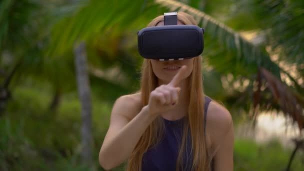 美しい若い女性のクローズ アップ ショットは、熱帯公園で Vr のヘッドセットを使用します。Vr メガネを身に着けている人は、彼は熱帯のように感じています。拡張現実感の概念 — ストック動画