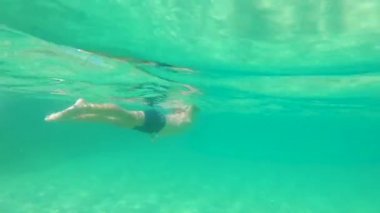 4k su altında snorkeling ile bir maske küçük şirin bir çocuk vuruldu ve bir tropikal deniz ile lots-in tropikal balıklar onu çevreleyen tüp