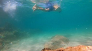 4 k Slowmotion çekim genç beyaz adam bir maske şnorkel ve tüp nefes bir tropikal balıklar dolu güzel bir deniz