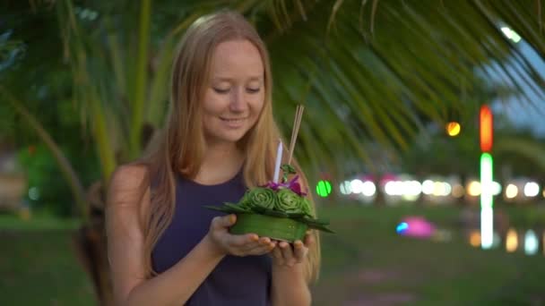 Slowmotion tiro de uma bela jovem segurando um krathong em suas mãos celebrando um feriado Loi Krathong na Tailândia — Vídeo de Stock