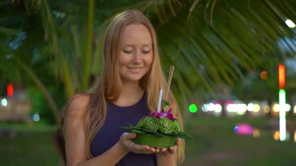 Fotografía en cámara lenta de una hermosa joven sosteniendo un krathong en sus manos celebrando una fiesta de Loi Krathong en Tailandia — Vídeo de stock