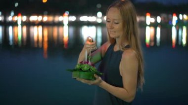 Güzel bir genç kadın Slowmotion çekim bir mum elinde bir Krathong tutarak Tayland bir Loi Krathong tatil kutluyor ışıkları