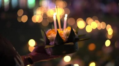 Onun elinde yanan bir mum ile bir Krathong tutan bir kişinin Slowmotion vurdu. Geleneksel bir Tayland tatili kutluyor-Loy Krathong
