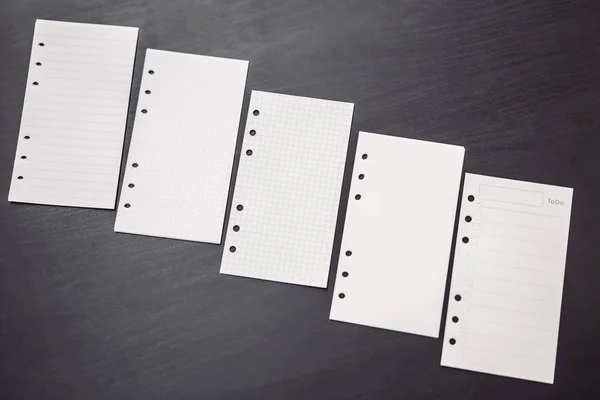 Different paper for notepad mocap on a black wooden background — Stock Photo, Image