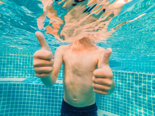 Подводный мальчик весело в бассейне с очками. Летние каникулы — стоковое фото