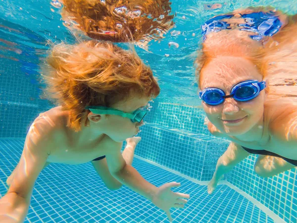 리틀 보가 아이 들고 어머니는 수영장에서 수영 하는 학습 — 스톡 사진