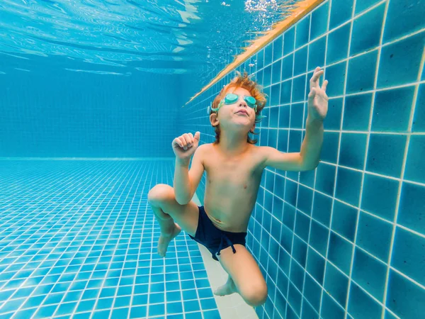 Unterwasserspaß für kleine Jungen im Schwimmbad mit Schutzbrille. Sommerferienspaß — Stockfoto